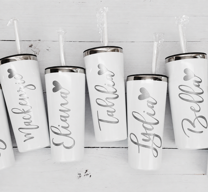 Set of white tumblers with personalized names on a light wooden background