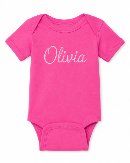 Pink baby onesie with 'Olivia' printed on it against a white background